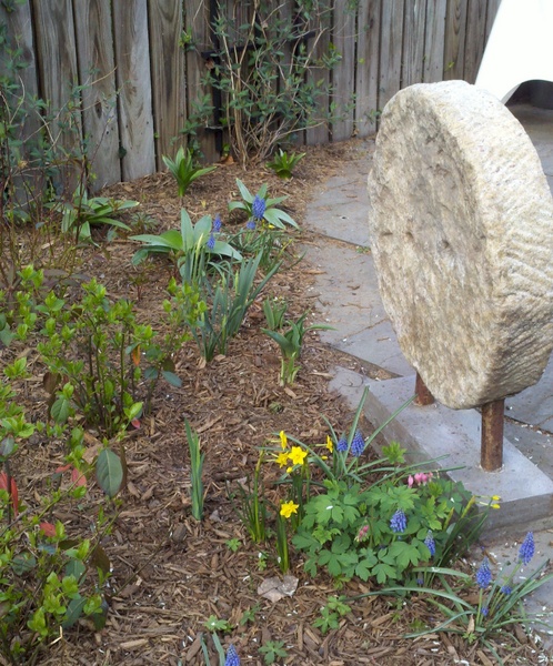 Antique Millstone as focal point in garden