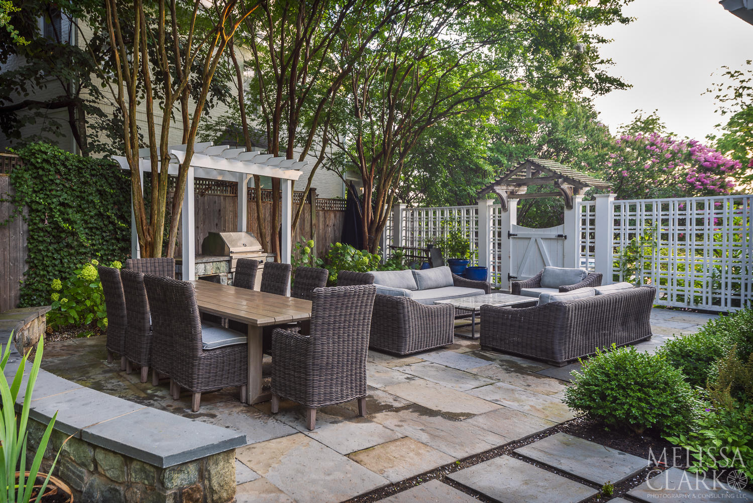 After: The expanded patio accommodates both dining and lounging.  The trellis was reconstructed and painted, but the original arbor over the gate was retained (including the lichens).  A pergola over the grill creates a separate kitchen space.